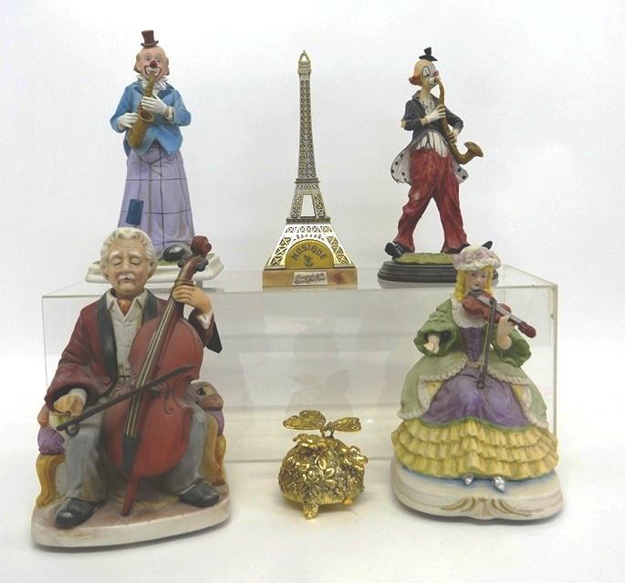 Three Waco Bisque Animated Music Boxes & Others: Three Bisque battery operated animated musical figurines by Waco, clown saxophone player 12.5"H, cellist, violinist, also includes a cast clown saxophone player signed Pucci 12"H, Eiffel Tower wind-up
