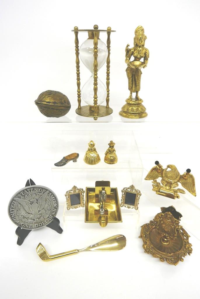 Lot of Decorative Brass & Metal Accessories: Heavy brass Thai figure 9.25"H, sand dial, ashtray cigarette pack holder, Bradley and Hubbard figural ashtray, eagle pen stand, pair of figural bells, golf club shoe horn, small picture frames, hinged