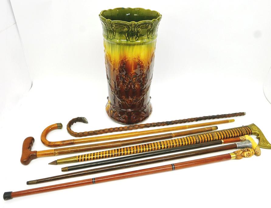 Group of Unusual Canes: Pryo decorated walking cane with a brass handle styled as a antique German axe, stick with carved bone and gold filled metal resembling a lady's leg, Cane with umbrella inside has a .830 silver handle