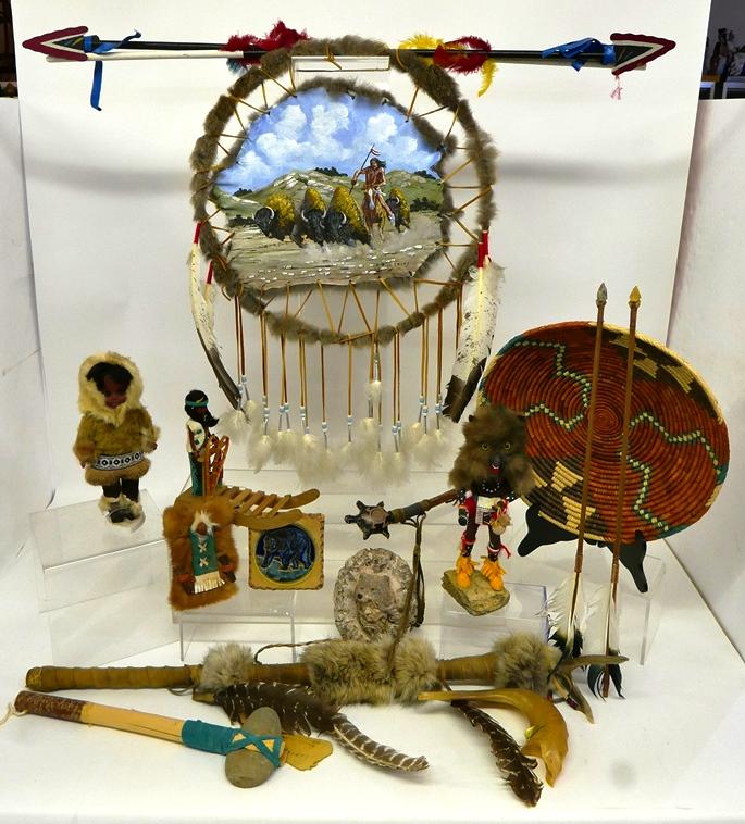 Native American Fur Trimmed Dolls & Crafts: Eskimo child dressed in real furs 11.5"H, Eskimo Art girl dressed in leather on wooden sleigh with hang tag 10"L, Indian baby on fur and leather bed 7.5"L, Native American Shield signed Rick Irons mad