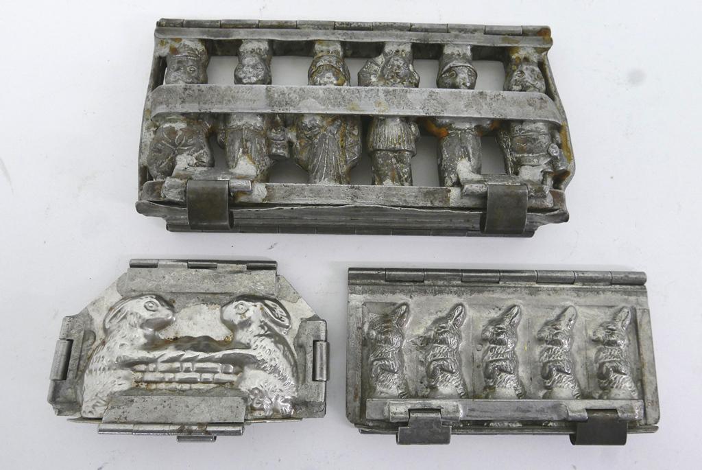 Three Rabbit Chocolate Molds: Three antique plated steel rabbit chocolate molds, six rabbits with different outfits 9"W signed Germany, five sitting rabbits 6.5"L signed DRGM, two rabbits with basket 5.5"W