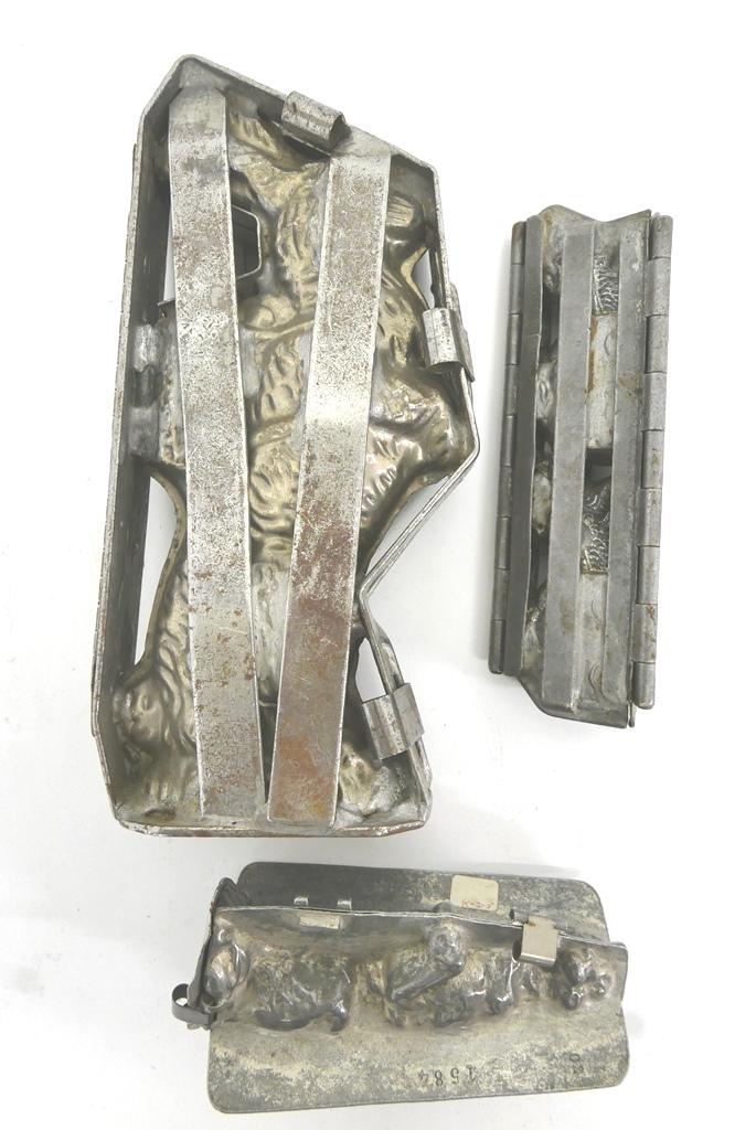 Three Rabbit Chocolate Molds: Three antique plated steel rabbit chocolate molds, large standing rabbit with basket on back 11"H, great little mold with two rabbits pulling a wagon filled with eggs signed Anion Dresden 8"L, sitting