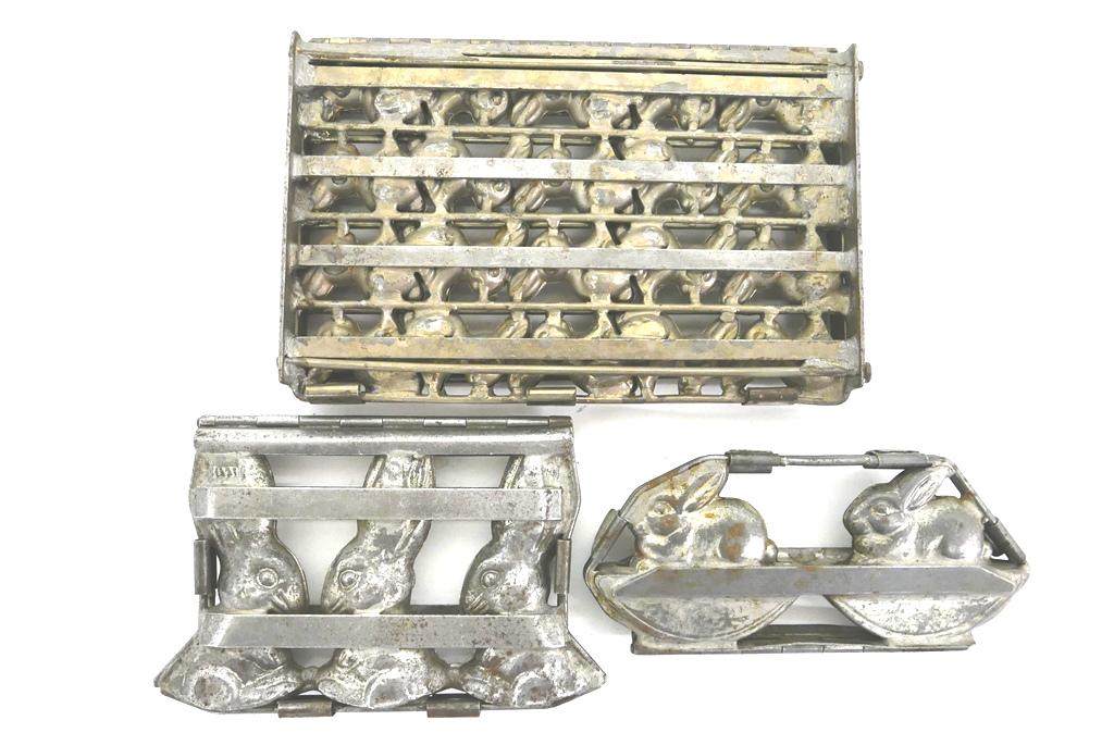 Three Rabbit Chocolate Molds: Three antique plated steel rabbit chocolate molds, mold for 20 sitting rabbits 7" by 11" marked Germany, mold for 2 rabbit rockers 9"W marked Weygandt New York Germany, mold with three rabbit heads 8.