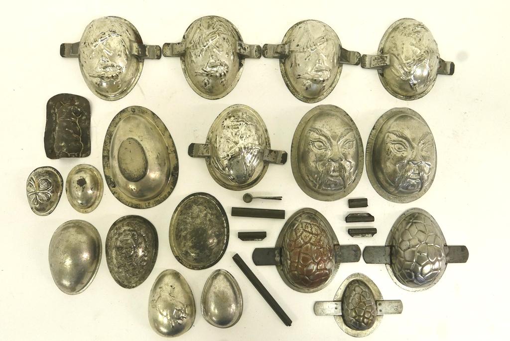 Antique Chocolate Egg Molds: Nice selection of chocolate molds, double sided molds include Fu Manchu, 2 pairs with floral scenes and turtle, 2 piece mold with girl holding doll on top only 4"H, single 1/2 molds for floral, pig an