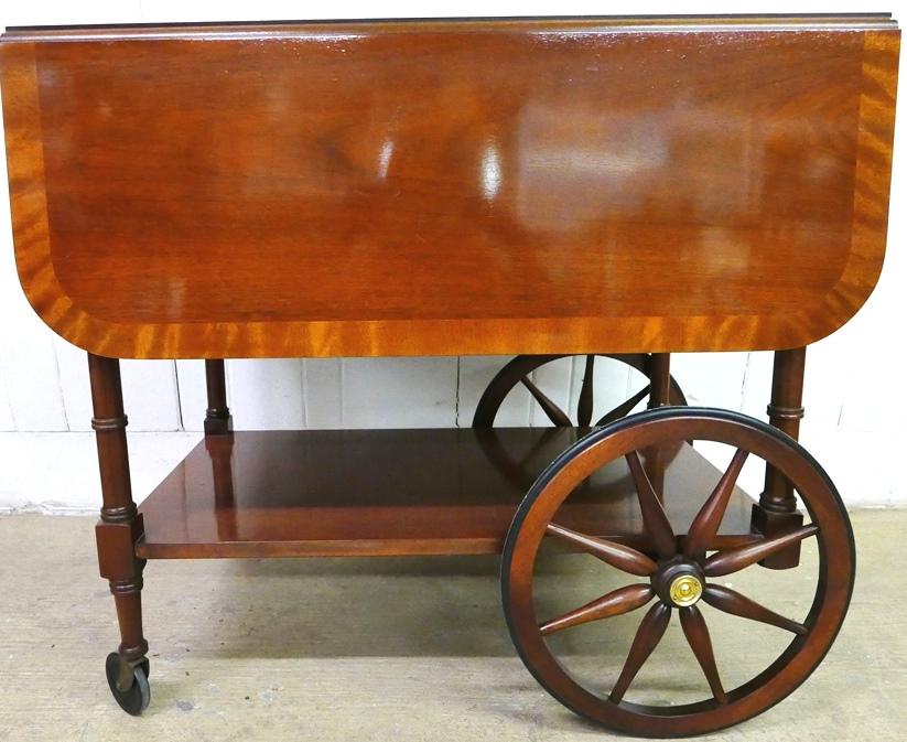 Baker Mahogany Tea Cart: Baker mahogany tea cart, double drop leaf top with burl veneer edging, single drawer over removable glass bottom tea tray, bottom shelf over base with 4 wheels, 32"L, 20.5"D closed, 42"D opened, 29"H