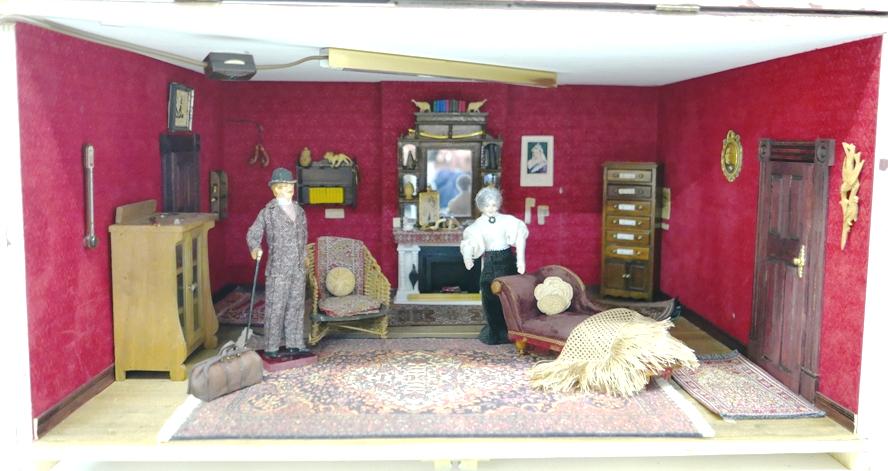 Sherlock Holmes Living Room Box Dollhouse: Painted plywood room box with hinged front has brass plate inscribed "MINI-TONGA BSI REGISTRY #9", bisque Sherlock doll has worn paint on face 6"H, bisque Mrs. Hudson 5.75"H, box has painted ceiling w