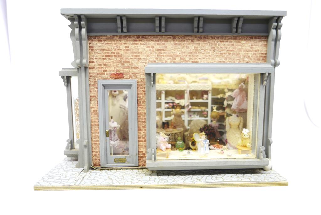 Dress Shop Room Box Dollhouse: Nice room wood room box with gingerbread trim, paint and brick printed paper on exterior, removable front wall for access, interior has built in lighting in ceiling, two rugs on floors, Enesco bride w