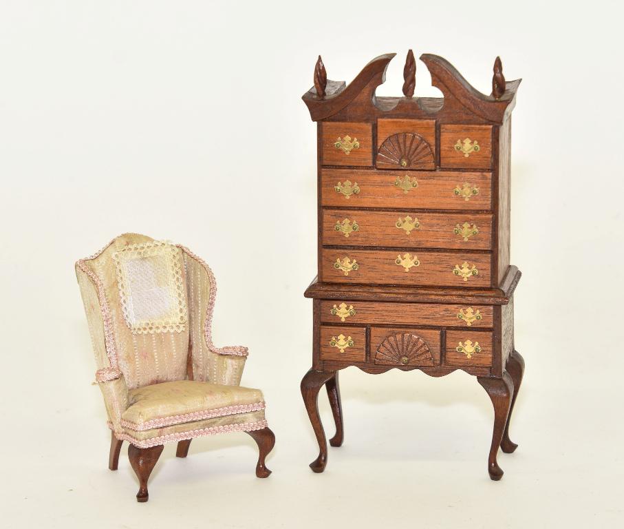 Mell Prescott Chest On Stand & Chair Miniatures: Vintage Mell Prescott mahogany high dresser, swan neck pediment with turned flame finials, two carved fans, scalloped skirt, cabriole legs 3.5"W, 7.25"H and a Queen Ann wing chair with turned arms 4"H