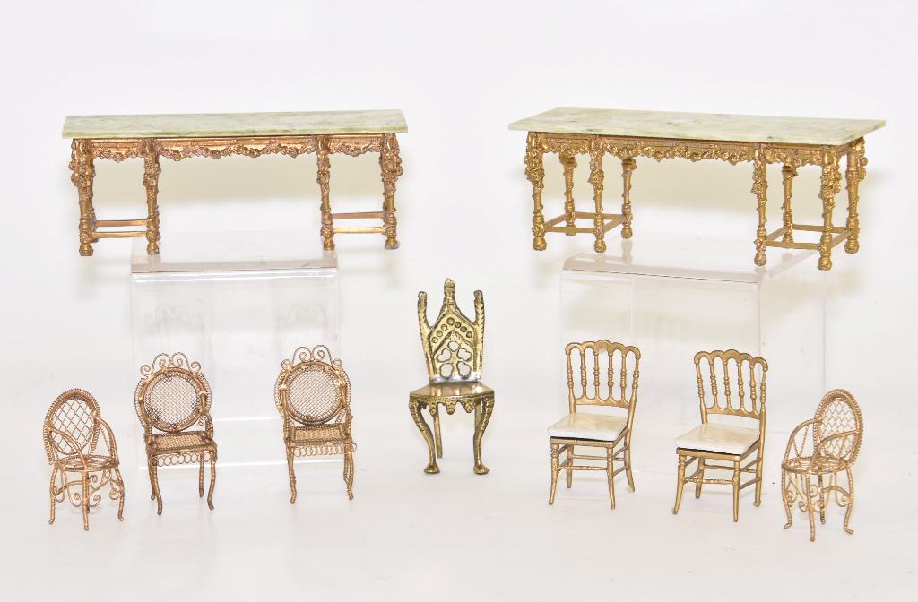 In the style of Kupjack Top Pier Tables Miniatures: Pair of very high quality marble top pier tables with heavy gold gilt cast base with high relief flowers and swags 6.75"L, 2.25"D, 2.5"H, includes a pair of cast metal side chairs 2 7/8"H with minor b