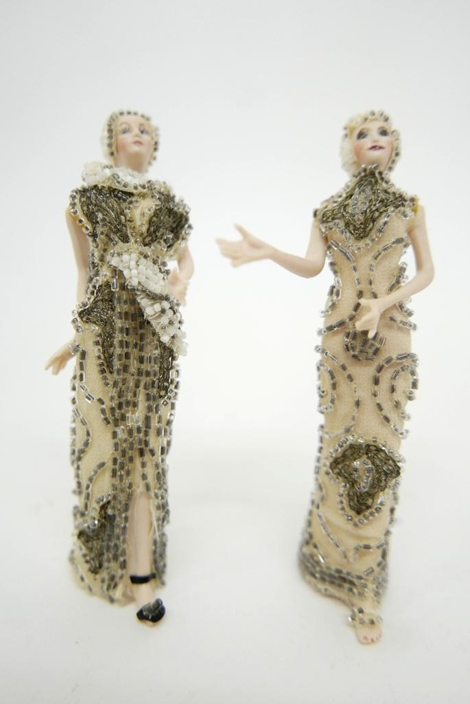 Two Bisque Dollhouse Dolls With Beaded Dresses: Two bisque dolls with jointed arms dressed in beaded fabric dresses and beaded headdresses, 5.25"H