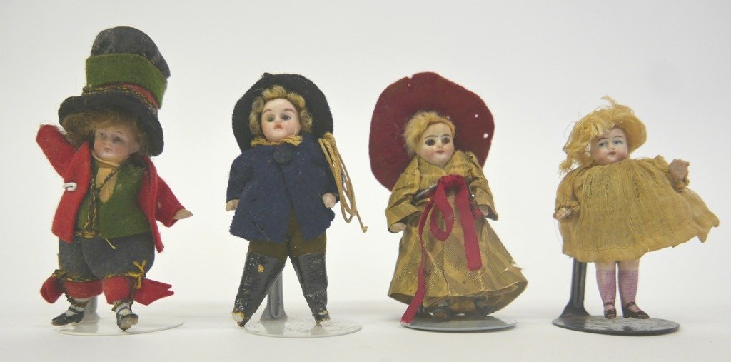 Four Antique Bisque Dollhouse Dolls: Four antique bisque dollhouse dolls with original clothes, girl with wide bonnet has glass eyes 3.5"H, boy with rope has glass eyes and a broken foot 4"H, bisque girl dressed as a Tudor page 3"H, bisq