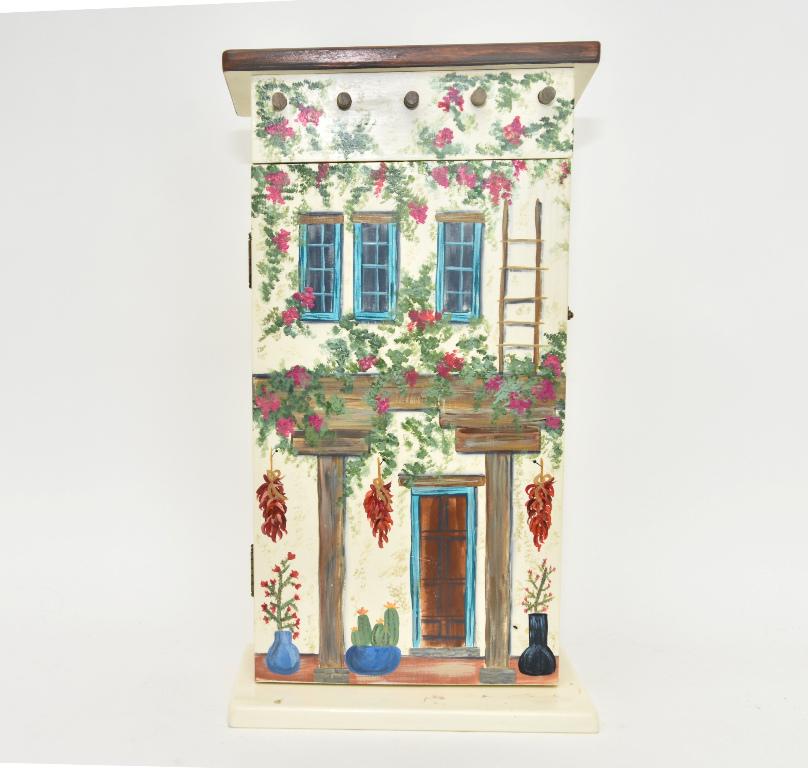 Hand Painted Dollhouse Hanging Cabinet: Wood cabinet with hinged front door painted to resemble a south-west two story home, interior has two removable shelves, 13"W, 7"D, 24"H