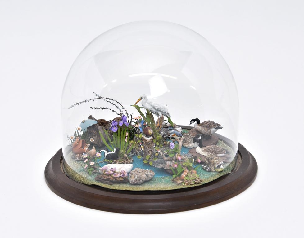 Mary McGrath Pond Diorama: Mary McGrath pond diorama under glass dome on wood base filled with animals and birds, stork, raccoon, geese, birds, chipmunks, pheasant, skunk, turtle, butterfly and mouse, 9.5"D, 7"H