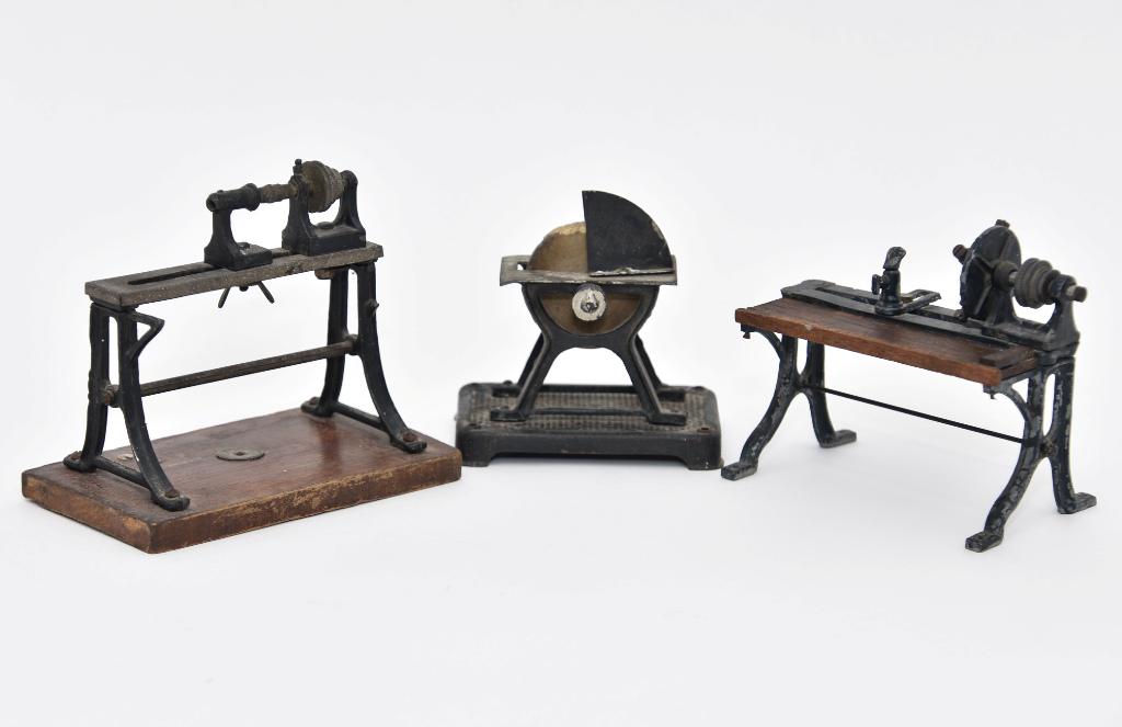 Three Antique Steam Driven Shop Tools: Three antique tools made to be driven by a toy steam engine, lathe with wood shelf 4.5"L, lathe on wood base 5"W, grinding wheel 3.5"L