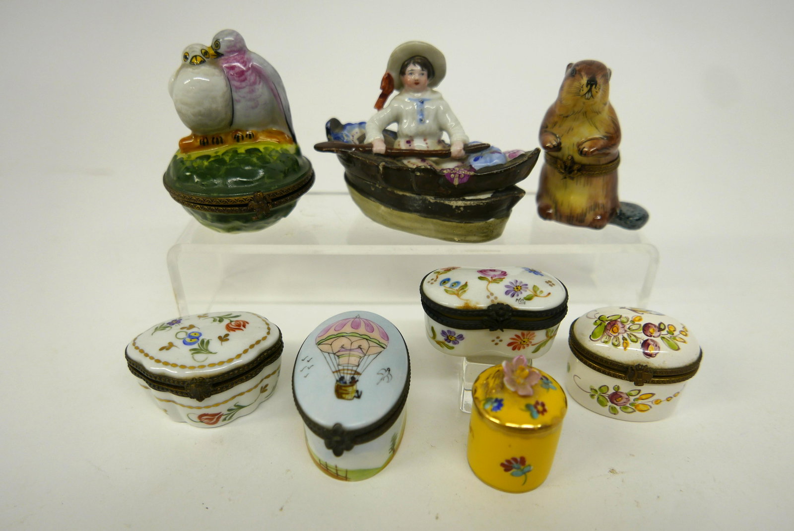 French & German Trinket Boxes: Six French Limoges trinket boxes including beaver 2.75"H, French Rockland oval trinket box painted with flowers, antique German rowboat trinket box with scattered paint wear 3.5"L