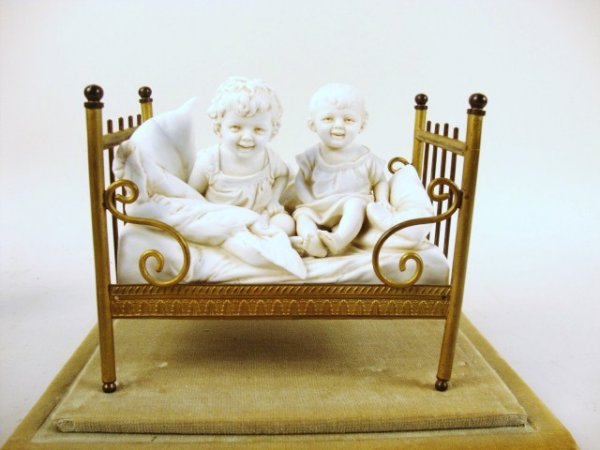 Parian Children in Brass Crib: Parian children figures in form-fitting brass crib, Victorian in style. Bed 5.25" L, Case 8" x 9" x 7 "