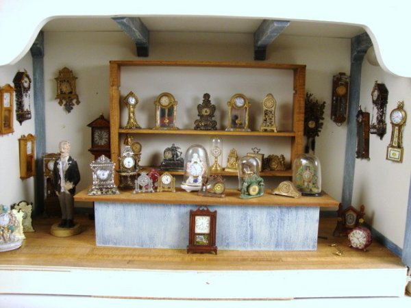 Clock Shop Roombox: Large wooden roombox furnished as a clock shop and displaying over 40 antique and vintage clocks of all descriptions, plus a Gottschalk shop clerk. Several of the clocks are under antique domes with n