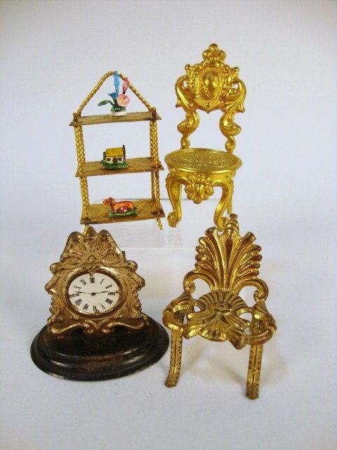 Nouveau Ormolu Hanging Shelf and Chairs: A diminutive ormolu 3-tiered wall shelf with embossed designs and displaying three Eugene Kupjack decorative knick-knacks 2.25" H, a pair of ormolu chairs and a tin mantel clock (base damaged).