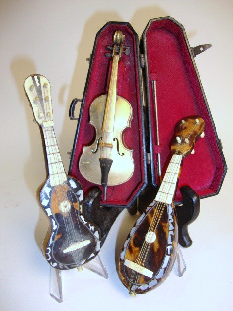 Assortment of Musical instruments: Antique tortoiseshell mandolin 5" L and guitar with mother-of-pearl and ivory trim (some loss), and a brass cello in its original leather-covered case.