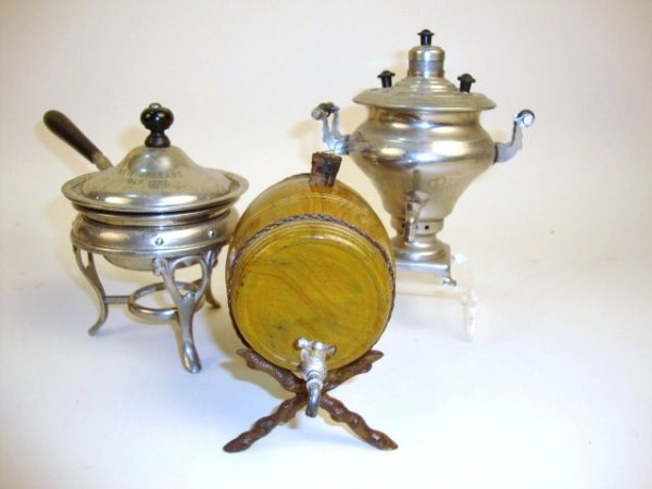 Large Scale Samovar and Chafing Dish: A Russian samovar 5.5" H with Cyrillic marking (spigot missing handle), a chafing dish marked as a souvenir of New Orleans 1907, and an unmarked cast metal keg on stand, probably German.