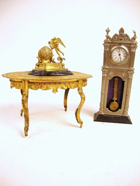 Ormolu Table and Two Clocks: Larger ormolu table with embossed top (5" L) spots and wax residue on top, plus a gilt mantel clock and tin tall case clock.