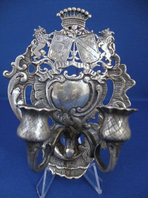 Two-light Candle Sconce with English Import Marks: Rococo wall plate with piercing, scrolls, rocaille and floral work, with an armorial pair of shields, lion and griffin figures with crown at the top and two compound c-scroll arms supporting tulip-sha