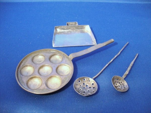 18th Century Dutch Egg Coddler and Two Straining S: The egg coddler of round body form with shallow lip, six hemispherical recesses around and one in the center, strap handle turned to a socket at its end, marked on the back of the handle with Amsterda