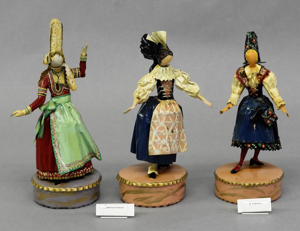 Three Lee Menichetti Artisan Sculptures: Lee Menichetti [New York & Palm Beach Florida 1931 - 1997] well known theatre related artist, hand bent and hand painted bent sheet brass sculptures depicting three tradition costumes from Switzerland
