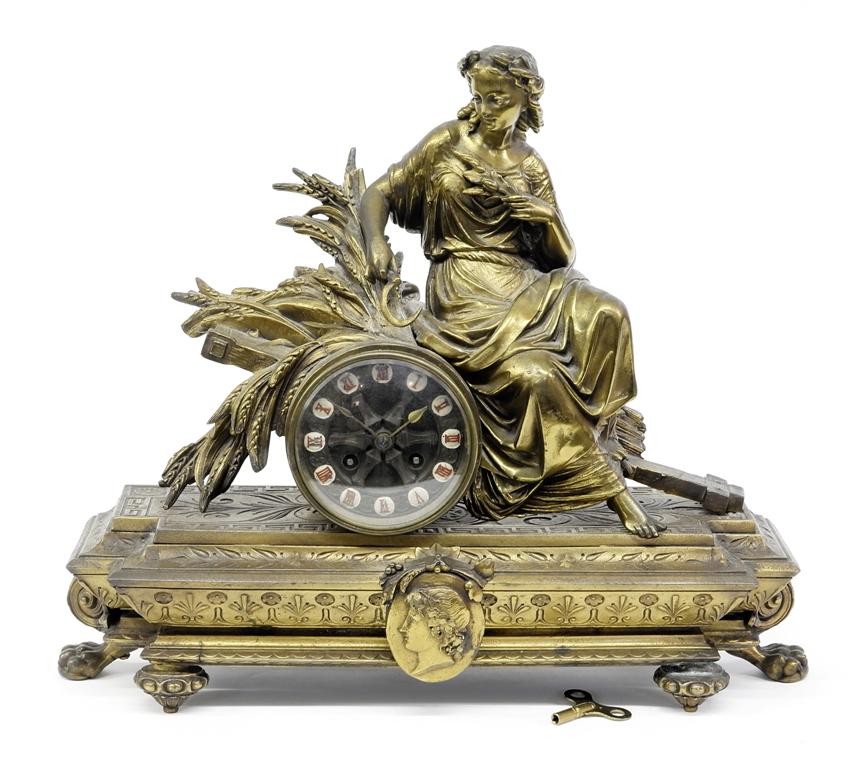 Antique French Figural Mantel Clock: Antique French figural mantel clock, figural symbol of abundance holding a scythe sitting on a wagon load of wheat, cast spelter case with applied bronze patina, cast brass dial with paint highlighted