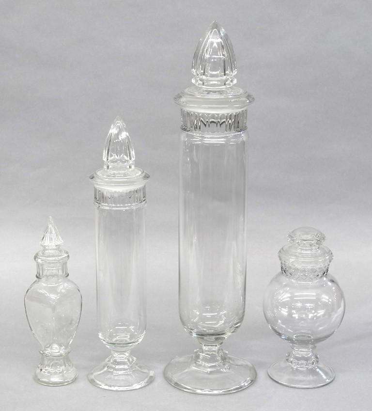 Four Large Glass Candy Store Containers: Vintage large glass candy container 26.5"H, large glass candy containers 20"H has several chips on lid rim, four sided candy container 12.5"H, bulbous candy container 12"H has small chips on top rim a