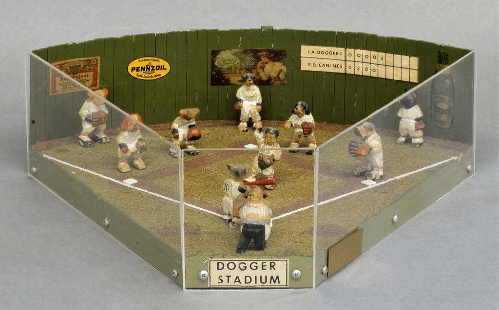 Susan Hendrix Dogger Baseball Game Diorama: Dogger Stadium has the hand carved wood L.A. Doggers playing the S.D. Canines, brass plate reads " Originals By Susan Hendris", 11 hand carved and painted players and umpire average height 2", 16"L, 1