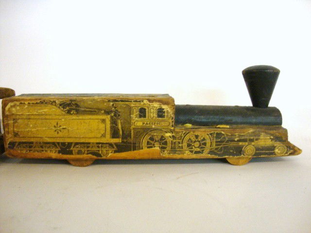 Vintage Wood Train 3 piece Set: Lot of three Wood trains w/paper lithographs on sides, engine is labeled Pacific and is 10"(l) x 2 1/8"(w) x 3 1/8"(h), 2 cars labeled Grand Excursion Train to Rocky Mountain & California size is 10"(