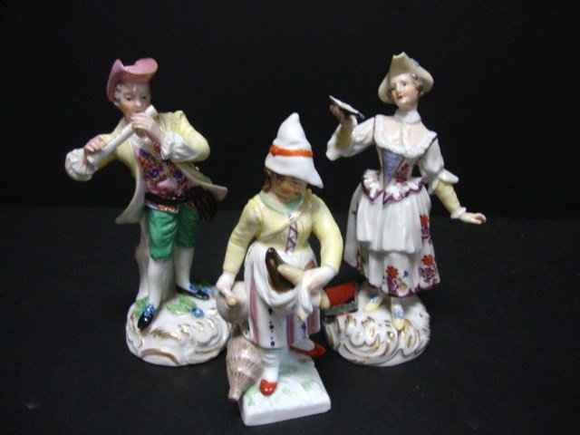 Three Porcelain Figurines: Porcelain Figure of woman reading a book 5 1/2 "(h) - porcelain figure of man playing a flute - faint stamp on bottom 5 1/2' (h), porcelain figure of woman holding jug & vegetables, faint blue mark 4 