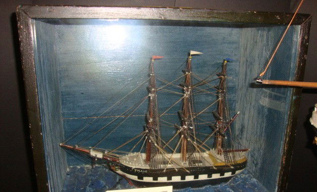 Early 20th Century Diorama: Early 20th century diorama with a waterline clipper ship passing by a lighthouse. Well executed model carries all standing and running cords, with varnished spars, mounted to a display case. Case dime