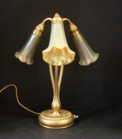 Three Light Lily Tiffany Lamp: A Tiffany Studios New York "Three Light Lilly" table lamp, featuring 3 golden Favrile style glass shades signed L.C.T.the shades are contemporary , base signed Tiffany Studios, New York #319, lamp 12 