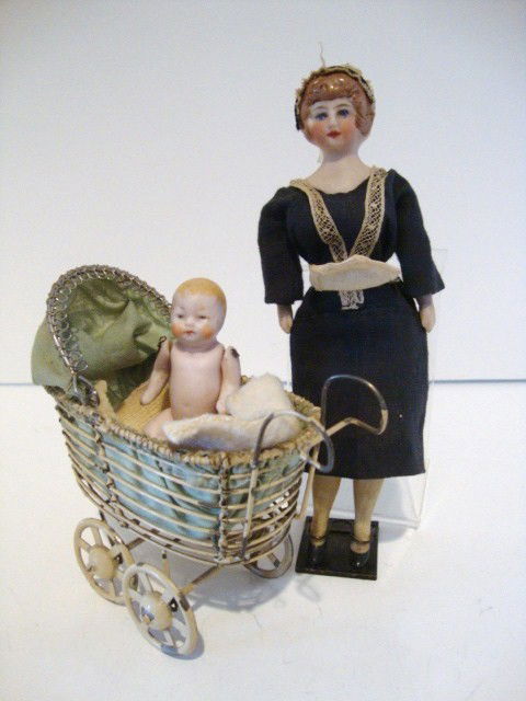 Bisque Dollhouse Doll: Bisque dollhousemaid #447 9/0 in original clohing with lace cap with vintage stand, together with vintage German wire carriage and all-bisque baby. Doll 6" H, Carriage 4" H, Baby 2 1/2" H, marked Germ