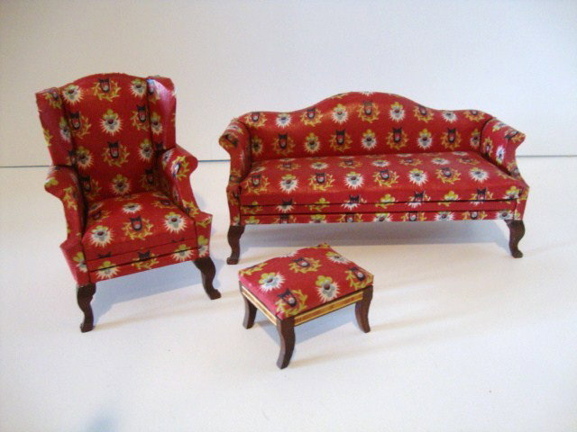 Lynnfield Parlor Set: An early matched set of Lynnfield furniture comprising a traditional camelback sofa, wing chair and footstool upholstered in a cheerful crisp red glazed chintz. Sofa 6.5" L.