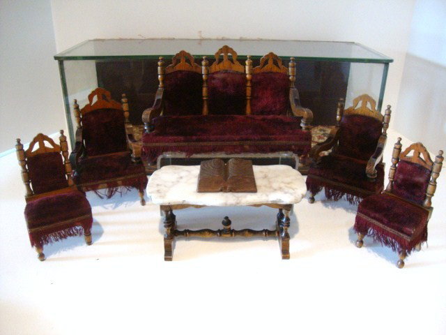 Schneegass Parlor Suite in Display Case: An antique glassed display case containing a set of larger scale antique Schneegass upholstered parlor furnshings including a settee approx. 8" L, two archairs, two side chairs, a marble-top library t