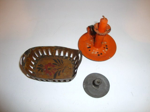 Early Tinware: A wonderful antique painted tin bread basket with floral decoration painted inside 2.75" L, 2" D, moderate paint wear, a painted tin candlestick (probably a Halloween decoration) 2" H and a small tin 