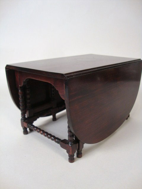 Mahogany Gate-leg Table: A fine mahogany drop-leaf gate-leg table with beautifully turned legs and joinery. Tabletop surface faintly marred by shadow of silverware bowl in the center. Opened, measures 12" L, 7.5" W and 4.25" 