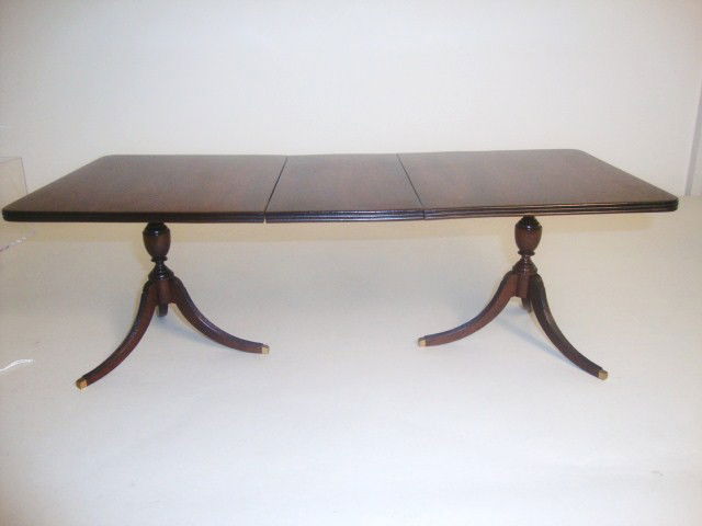 Large Mahogany Dining Table: An imposing Duncan Phyfe mahogany dining table with leaf, fluted carving on the tabletop edge and sabre feet, beautifully turned urn-shaped pedestal bases, lovely patina. With the leaf inserted measur