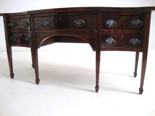 Mahogany Hepplewhite Sideboard: Handsome serpentine-front sideboard with five drawers featuring handsome molded pulls and tiny brass escutcheons. Tiny nicks in the finish on top, otherwise very fine.10" L, 5" H, 4" D.