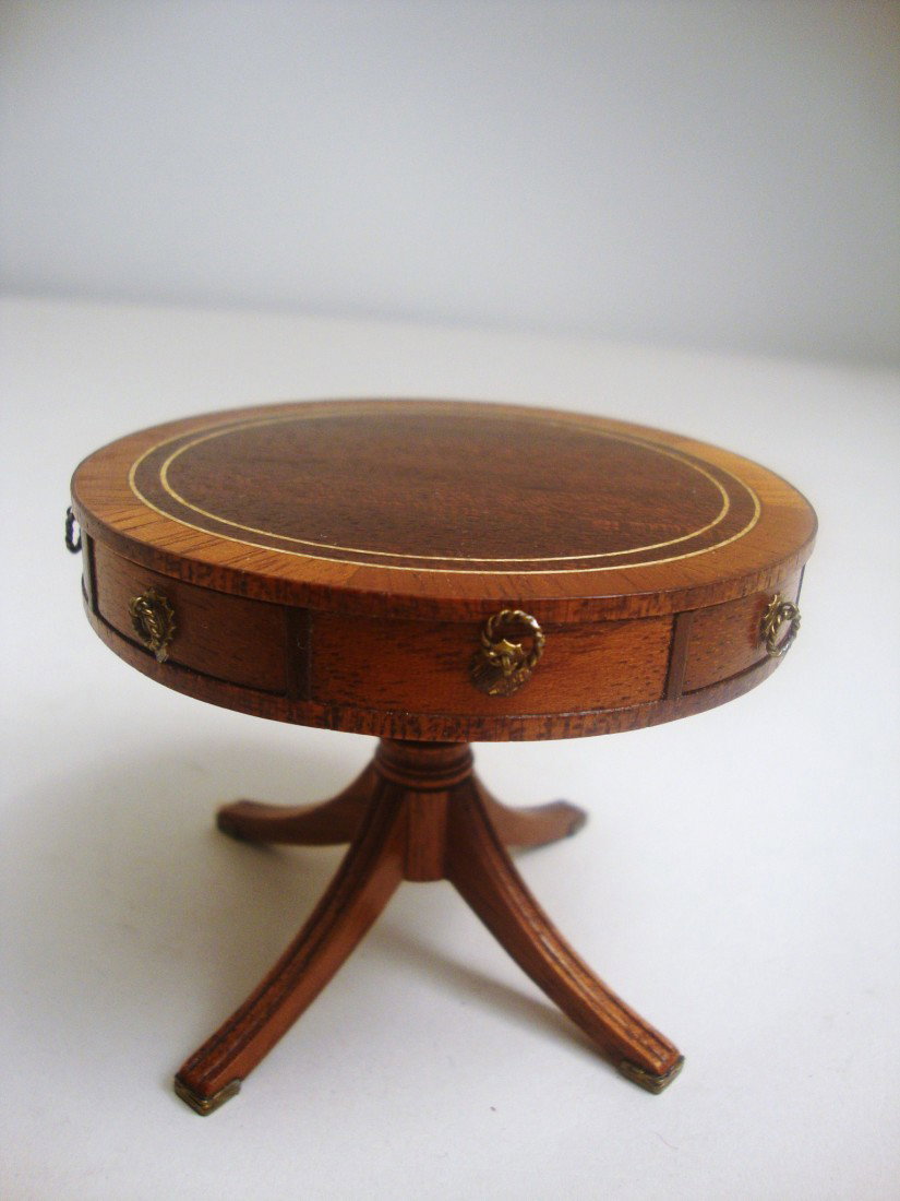 Artisan Drum Table: An elaborately inlaid drum or rent table made of mahogany and other woods with brass foot mounts and eight drawers. Signed underneath HC 1993. 2.5" H, 3" dia.
