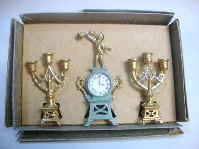 French Style Mantel Clock: Paint decorated garniture set with figural clock and matching candlesticks, in original box