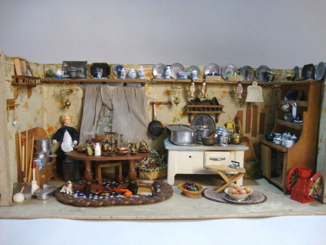 German Kitchen Roombox: Fully furnished antique kitchen roombox 10.5" H, 24.5" L and 10.25" D, with metal stove, old wooden table, chair and cupboard and a very generous assortment of old metal and pottery accessories.