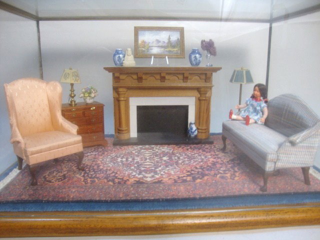 Parlor Roombox: A glass enclosed roombox furnished as an intimate little parlor furnished with d. Anne Ruff sofa and chair, X-acto chest of drawers, Karen Barone original oil painting and a vintage Caco girl. 14" L, 