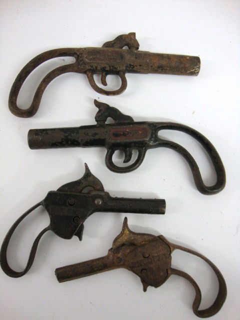 Early Cast Iron Cap Gun Lot: Four Cast Iron Loop-handle Cap Guns, one embossed HOT SPUR single action, one embossed SHOO FLY single action both 4" (l) 2 solid cast non-firing versions unmarked both 5" (l)