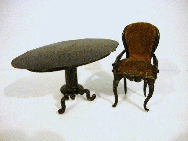 Antique Rock & Graner Table and Chair: A German tin pedestal table 3" H and 5" L with original painted finish showing appropriate wear, and an upholstered painted tin armchair 4" H, shows wear.