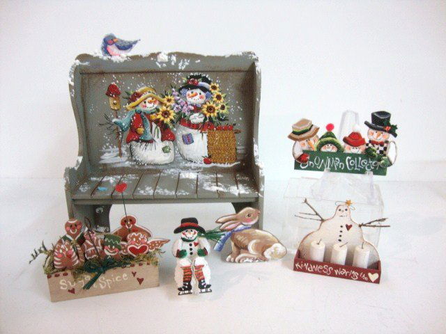 Karen Markland Christmas: Snowmen and sunflowers decorate Karen's settle bench 3.5" L and H accompanied by a wooden basket of gingerbread figures, a wall plaque, candle sconce and seated snowman painted with colorful exuberanc