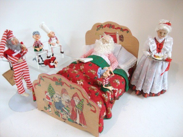 The Night Before The Night Before Christmas: Reclining Santa checks his list twice surrounded by five helpers and Mrs. Claus 5.5" H, all by Dorothy Haws. 1992 IGMA auction item.
